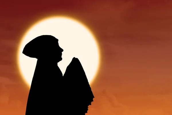 Sylwetka tło pomarańczowy zachód słońca muzułmańskich kobiet — Zdjęcie stockowe