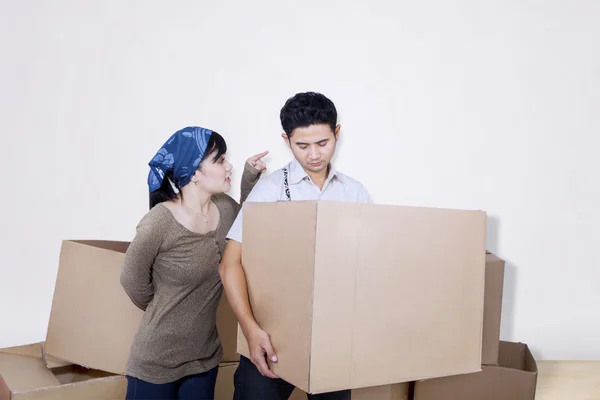 Vriendje brengen vak op wit met boos vriendin — Stockfoto