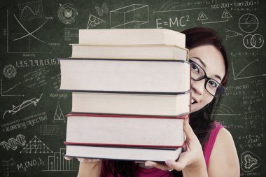 yakın çekim kız öğrenci sınıfta kitap yığını getir