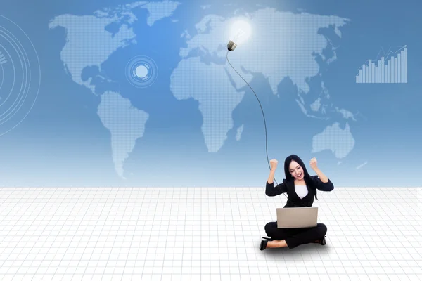 快乐女商人与便携式计算机和灯泡上蓝色世界地图 — 图库照片