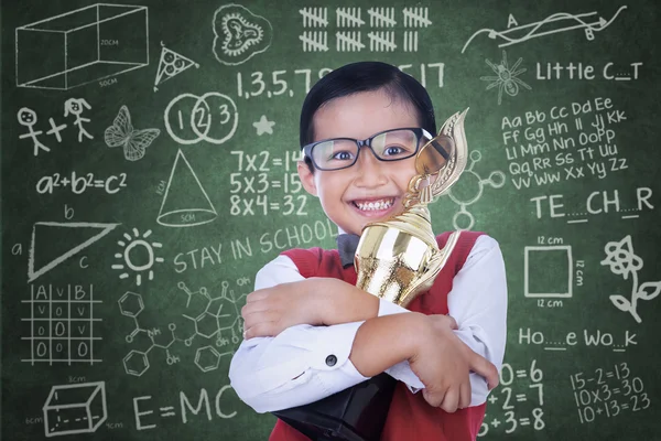 Asiático menino segurando troféu na classe — Fotografia de Stock