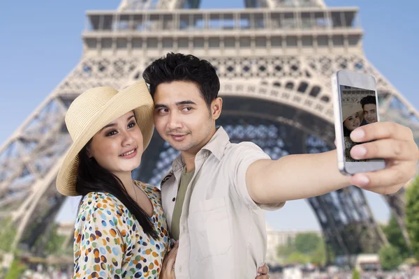 Una pareja toma una foto en la Torre Eiffel, París — Foto de Stock