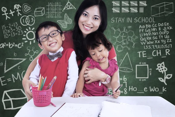 Famiglia felice in posa in classe — Foto Stock