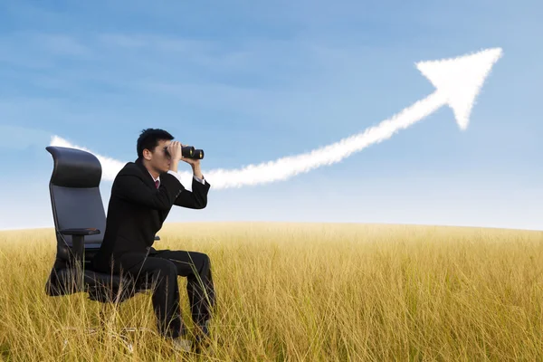 Empresário usando binóculos olhando para a crescente nuvem gráfico — Fotografia de Stock