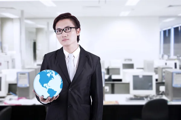 Empresario mantener mundo globo en la oficina — Foto de Stock