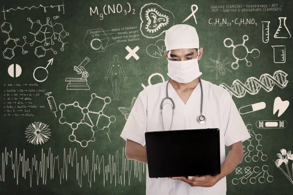 Health practitioner hold laptop on drawn chalkboard — Stock Photo, Image