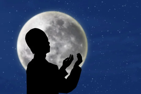 Silhouette of muslim man praying under blue moon — Stock Photo, Image