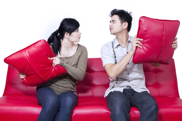 Casal lutando no sofá vermelho isolado — Fotografia de Stock