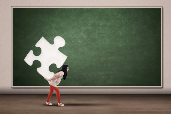 College student carrying piece of puzzle — Stock Photo, Image