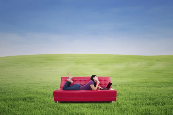 Mujer con portátil en el sofá al aire libre — Foto de Stock