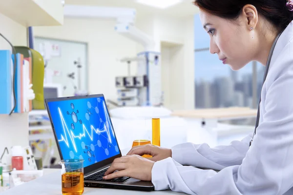 Aantrekkelijke arts werkzaam met laptop in lab — Stockfoto