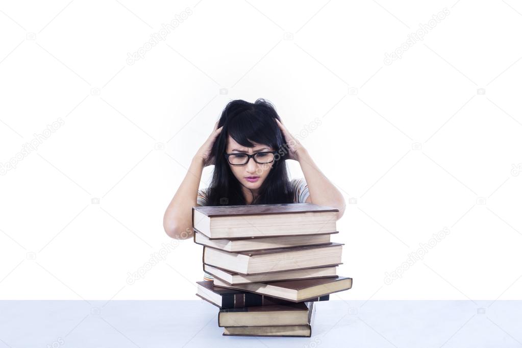 Attractive female student stress looking at books - isolated