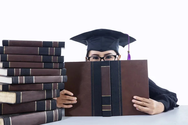 Afstuderen student meisje die betrekking hebben op haar gezicht op witte achtergrond — Stockfoto