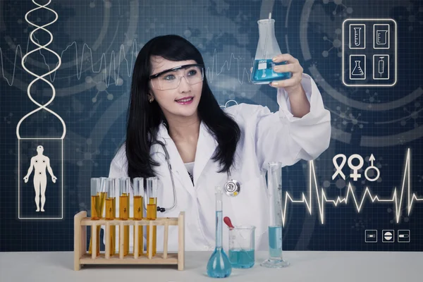 Schöne Wissenschaftlerin analysiert Lösungen auf blau — Stockfoto