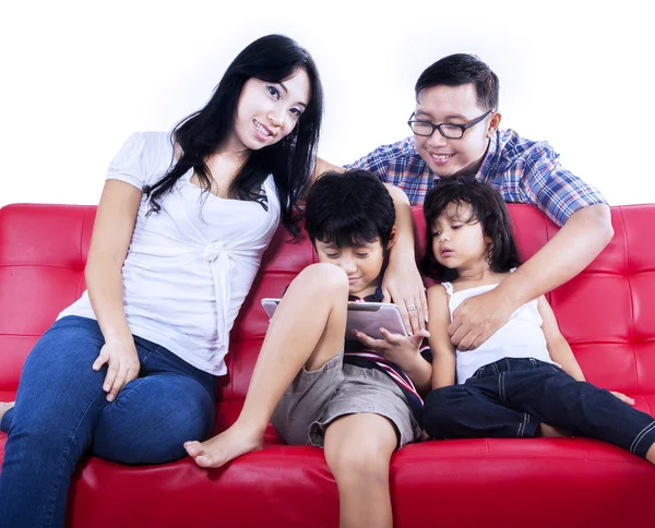 Asiatische Familie auf rotem Sofa — Stockfoto