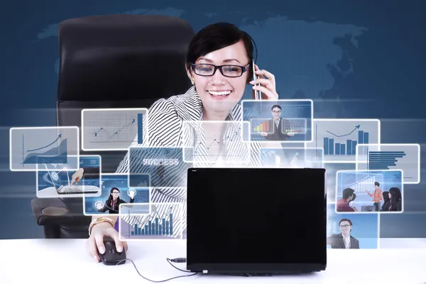 Businesswoman calling and networking using laptop Stock Photo