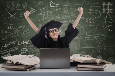 sınıf içinde laptop ile neşeli mezunu