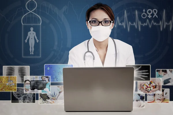 Aziatische arts kijken naar digitale foto's op laptop — Stockfoto