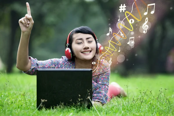 Asiática mujer disfrutar de la música en verde campo — Foto de Stock