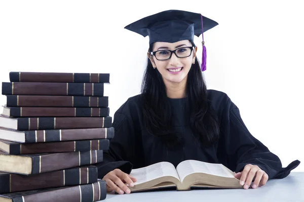 Asiatische weibliche Absolventin liest Bücher auf weißem Hintergrund — Stockfoto