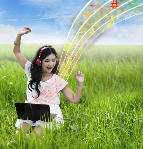 Gyönyörű női hallgató-hoz zene-ra laptop - kültéri — Stock Fotó