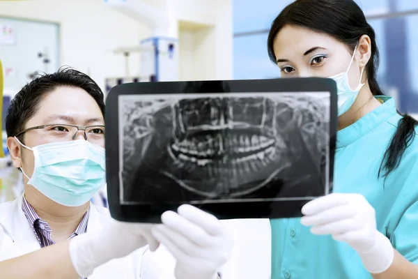 Assistente atraente e dentista olhando para raio-x no hospital — Fotografia de Stock