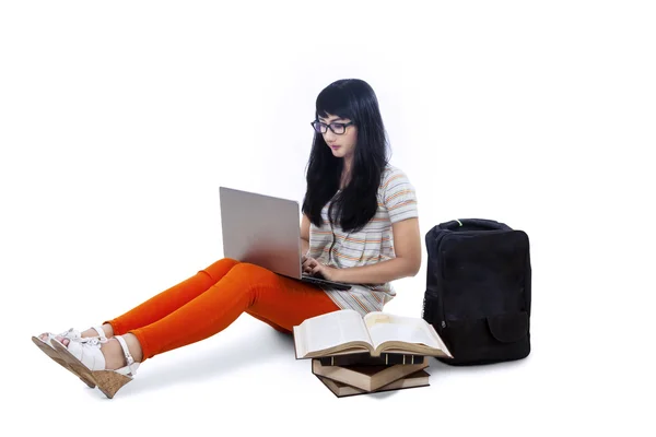 Asian female student typing on laptop - isolated — Stock Photo, Image