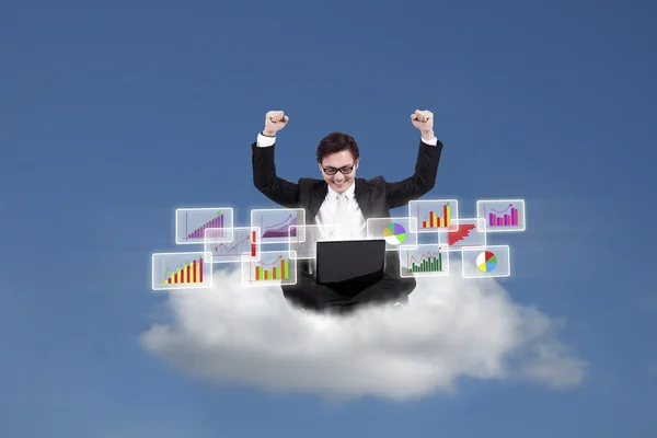 Happy businessman looking at bar graphs on cloud — Stock Photo, Image