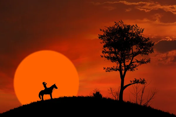 Horse rider silhouet bij oranje zonsondergang — Stockfoto