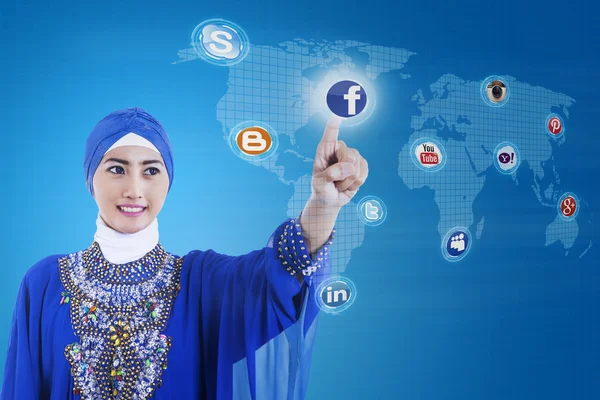 Азиатский мусульманин подключился к социальным сетям синего цвета — стоковое фото