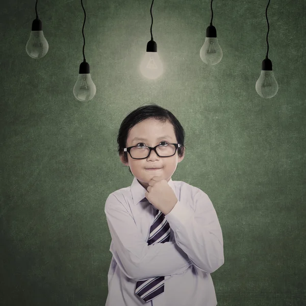 Business boy thinking under lamps — Stock Photo, Image