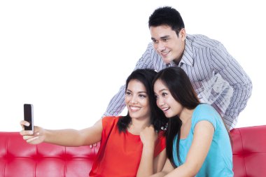 Üç genç arkadaşlar cep telefonuyla fotoğraf çekme