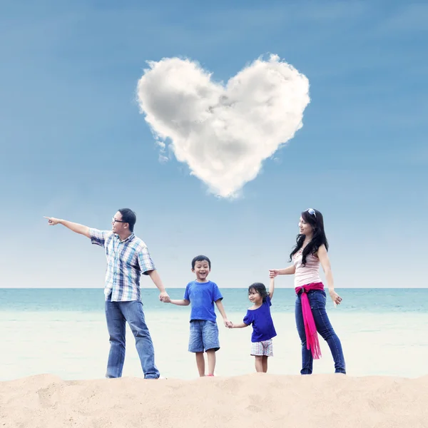 Familia asiática bajo la nube de corazón en la playa —  Fotos de Stock
