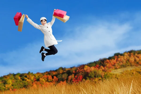 Excited woman jump with shopping bags — Stock Photo, Image