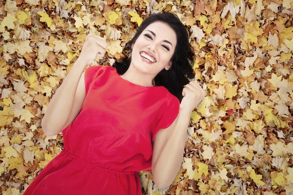Szczęśliwa młoda kobieta w jesień liście pomarańczowy — Zdjęcie stockowe
