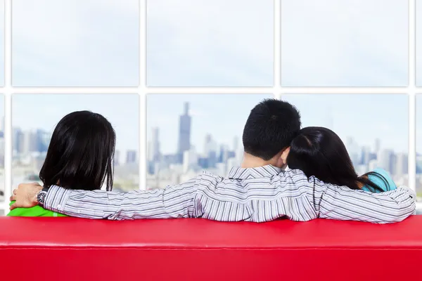 Duas mulheres e um homem olhando paisagem urbana — Fotografia de Stock