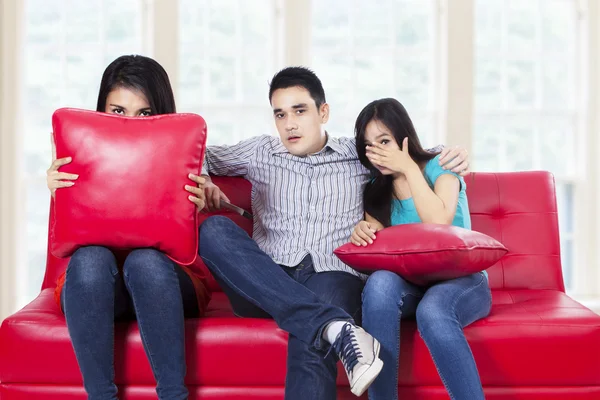 Three young teenagers watching TV Stock Photo