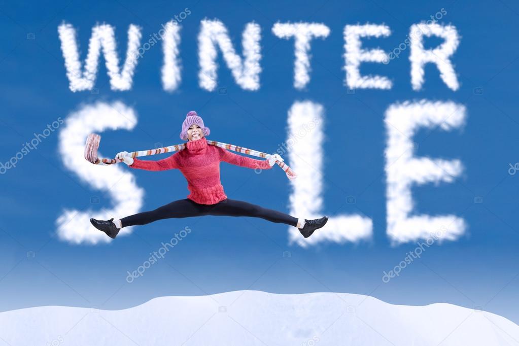 Woman jumping in winter sale