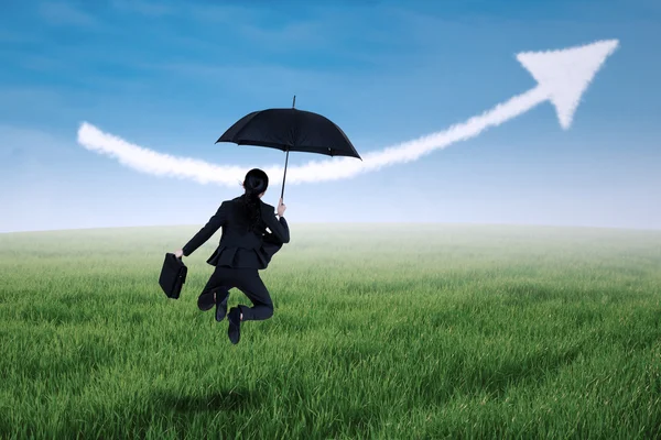 Businesswoman jumping with umbrella — Stock Photo, Image