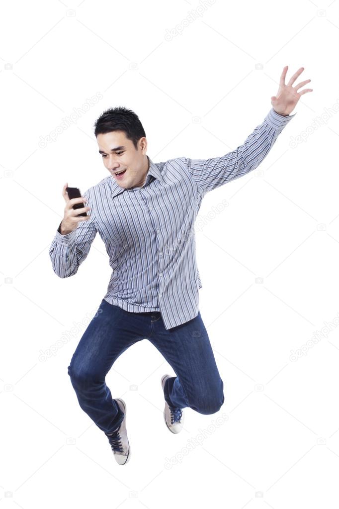 Young man jumping with a mobile phone