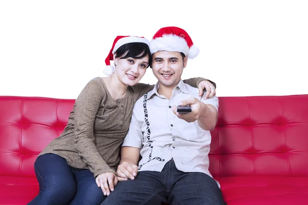 Christmas couple watching TV sitting at sofa — Stock Photo, Image