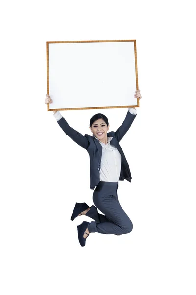 Saltando excitado empresária segurando placa em branco — Fotografia de Stock