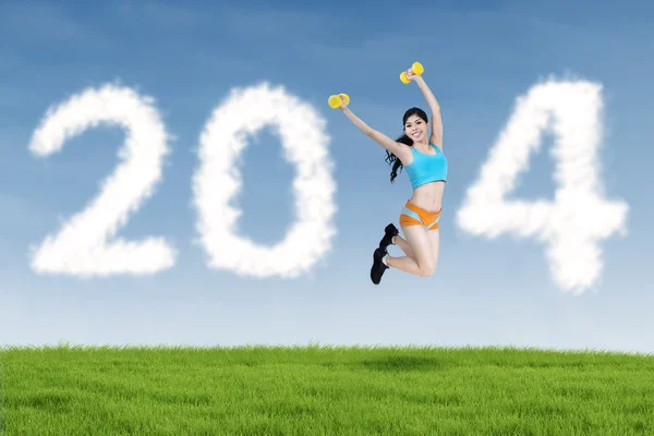 2014 Nieuwjaar wolken en fitness vrouw springen — Stockfoto