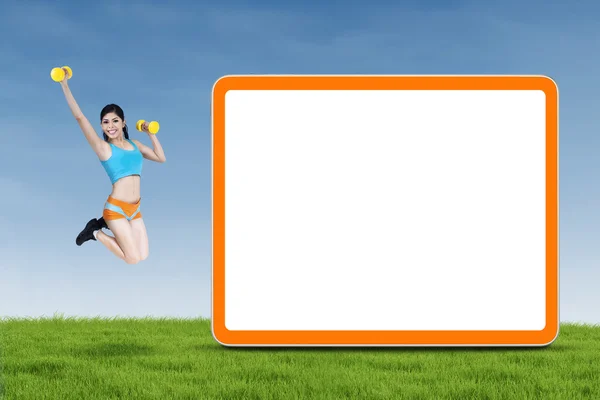 Athletic woman jumps next to empty board — Stock Photo, Image