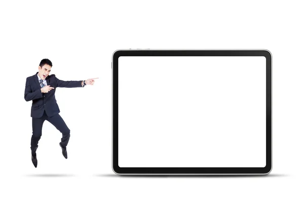 Businessman jumps and pointing digital tablet — Stock Photo, Image