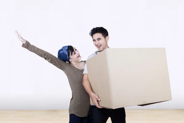 Emocionada pareja traer caja en casa nueva — Foto de Stock