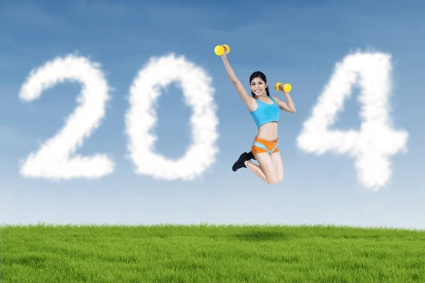 Fitness young woman jumping with new year 2014 — Stock Photo, Image