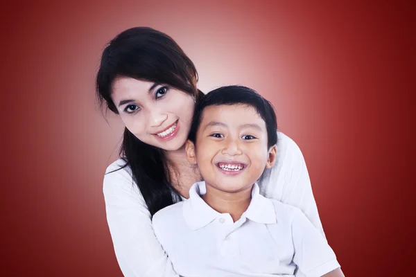 Beautiful mother and son on red — Stock Photo, Image