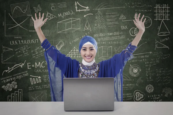 Happy female muslim with written board and laptop — Stock Photo, Image
