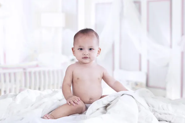 Schattige Aziatische baby glimlachend in de slaapkamer — Stockfoto